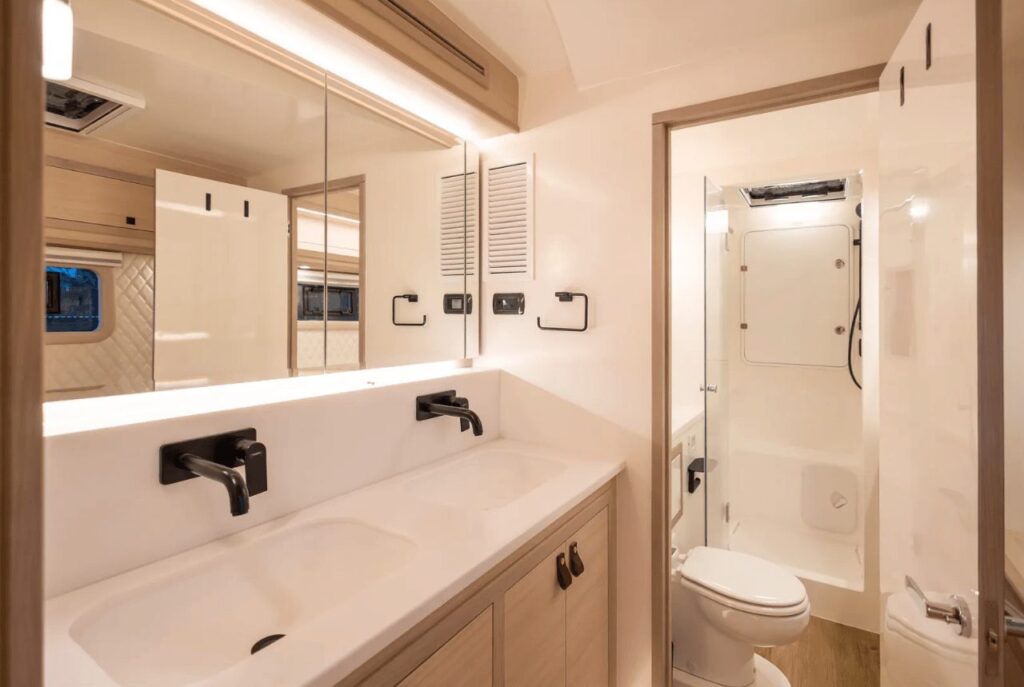 Twin-basin bathroom aboard Blue Jacket II with a stone vanity and black tapware