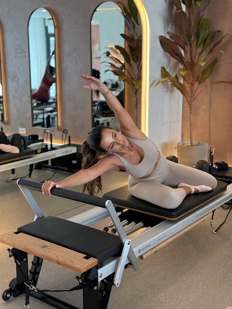 A client stretching on a reformer in the Lumea Pilates studio